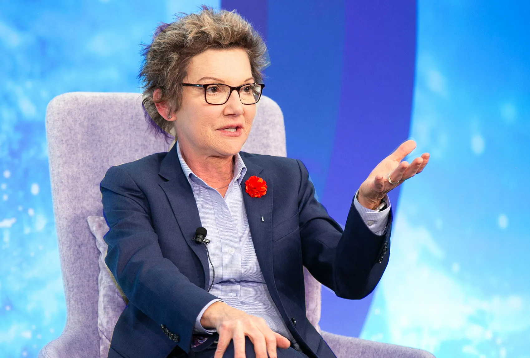 Person speaking at an event with gesture.